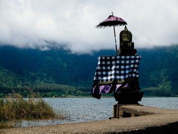 Woman standing on mountain against cloudy sky