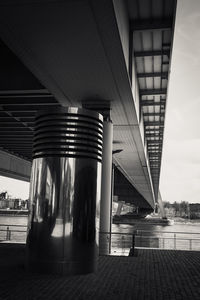 Low angle view of bridge amidst buildings against sky