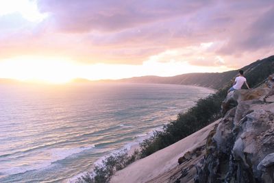 Scenic view of sea against cloudy sky during sunrise