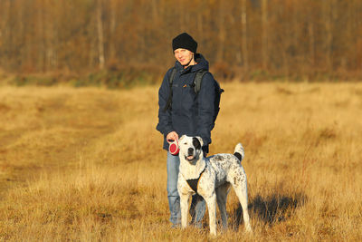 Man with dog standing on field