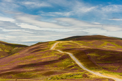 Scenic view of hills against cloudy sky