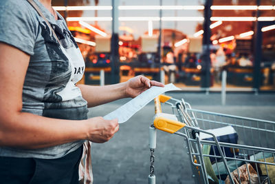 Woman looking at higher prices on receipt after shopping in grocery store. inflation growing prices