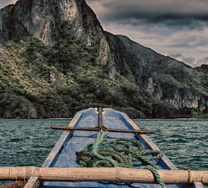 Scenic view of sea by mountains against sky