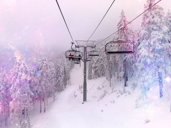 Ski lift over snow covered land against sky