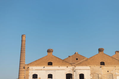 Low angle view of historic building against clear blue sky