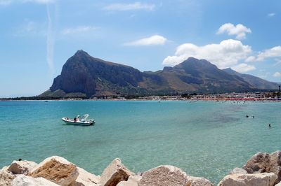 Scenic view of sea and mountains against sky