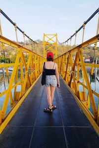 Full length of woman standing on bridge against sky