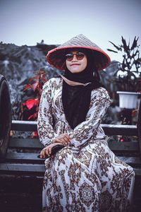 Portrait of young woman wearing hat standing outdoors