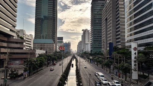 Traffic on city street amidst buildings against sky