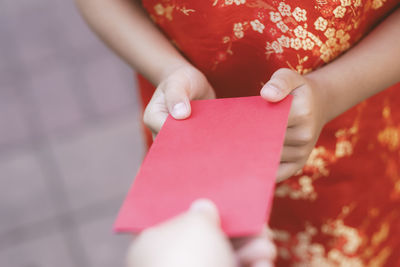 People giving red envelope (ang pao) to child.