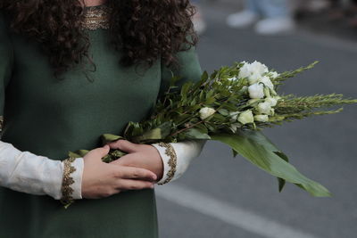 Midsection of woman holding bouquet