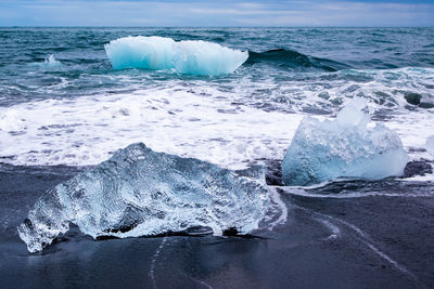 Ice on shore at beach during winter