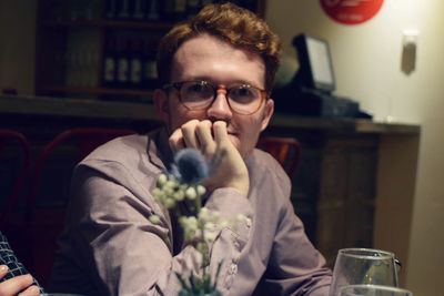 Portrait of young man sitting at table