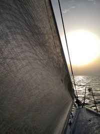 Close-up of sailboat on sea against sky during sunset