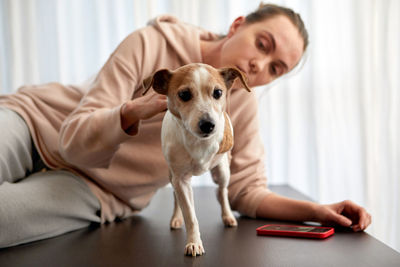 Pet owner supports the three-legged dog sitting at table