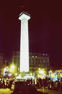 People on illuminated building at night