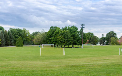 Goal posts on playing field against cloudy sky