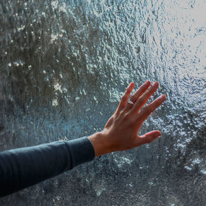 Cropped hand of woman reaching water