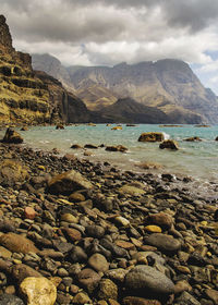 Scenic view of sea and mountains against sky