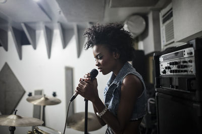 Young female singer performing in a studio