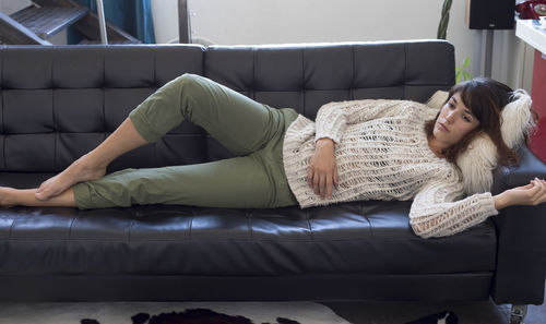 Woman lying on sofa at home