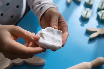 Cropped hand of person holding dentures