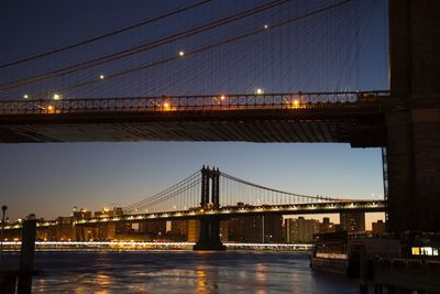 Low angle view of bridge over river at dusk