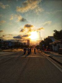 Vehicles on road at sunset