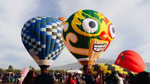 People on hot air balloon against sky