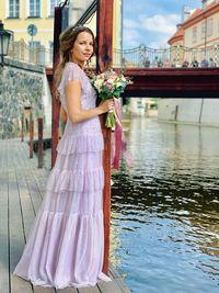 Young woman standing by railing at night