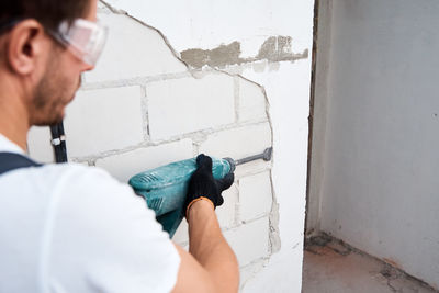 Portrait of man working on wall