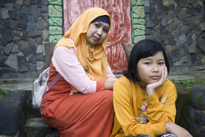 A little girl and her mother were sitting relaxed in front of the terrace