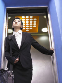 Low angle view of businesswoman exiting elevator