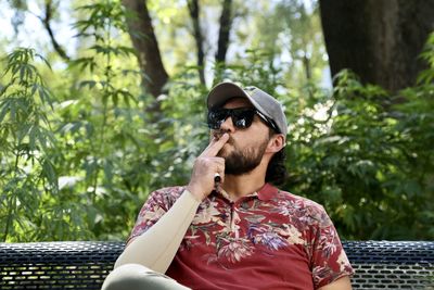 Portrait of young man smoking marijuana in public place