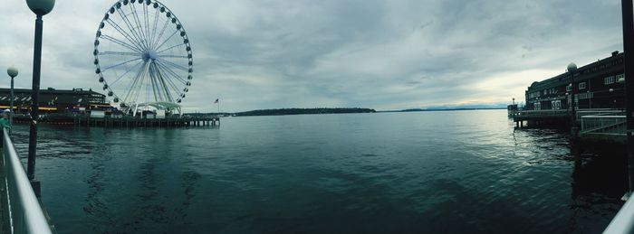 Boats in sea against cloudy sky