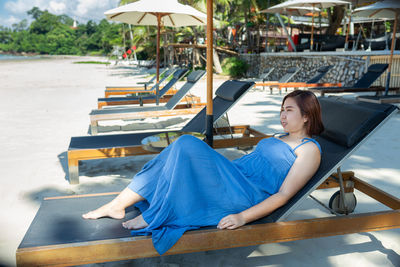 Young woman sitting on chair at beach