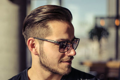 Close-up of young man wearing sunglasses in sunny day