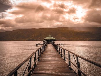 Pier over lake against sky