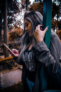 Midsection of young woman using mobile phone