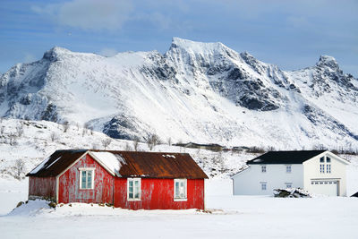 Houses on snow covered landscape against sky