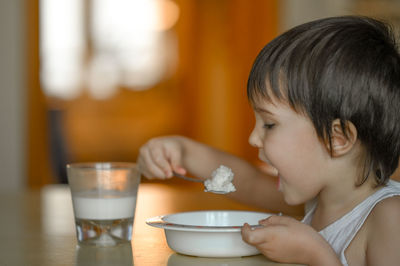 Close-up of girl eating food at home