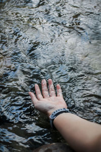 Cropped hand of woman touching river water