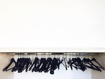 Close-up of shoes hanging on floor against white background