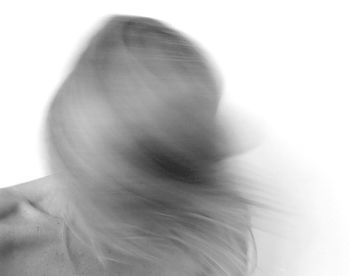 Close-up of woman holding hair over white background