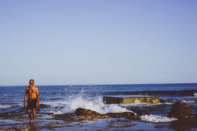 Man on beach against clear sky