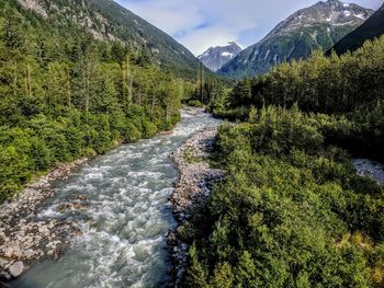 Scenic view of river amidst mountains against sky