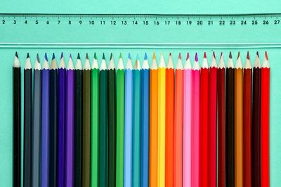 Close-up of colored pencils on table by ruler