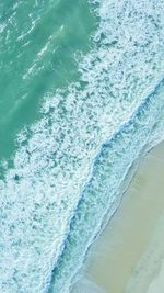 High angle view of waves rushing towards shore