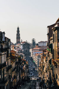 Road amidst buildings in city against clear sky