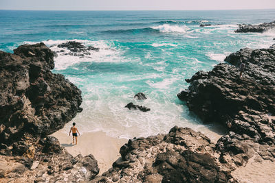 High angle view of people on rocks at sea shore